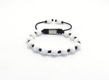 Cargar imagen en el visor de la galería, Pulsera realizada a mano en cordón nylon de 1.5 mm de grosor en color azul marino, con bolas de piedras naturales JASPE BLANCO de 8mm de diámetro separadas por un nudo doble; cierre ajustable muy cómodo con una "Taba" grabada a láser con nuestra marca DISORDER , terminación de la pulsera con dos bolas iguales en las puntas.